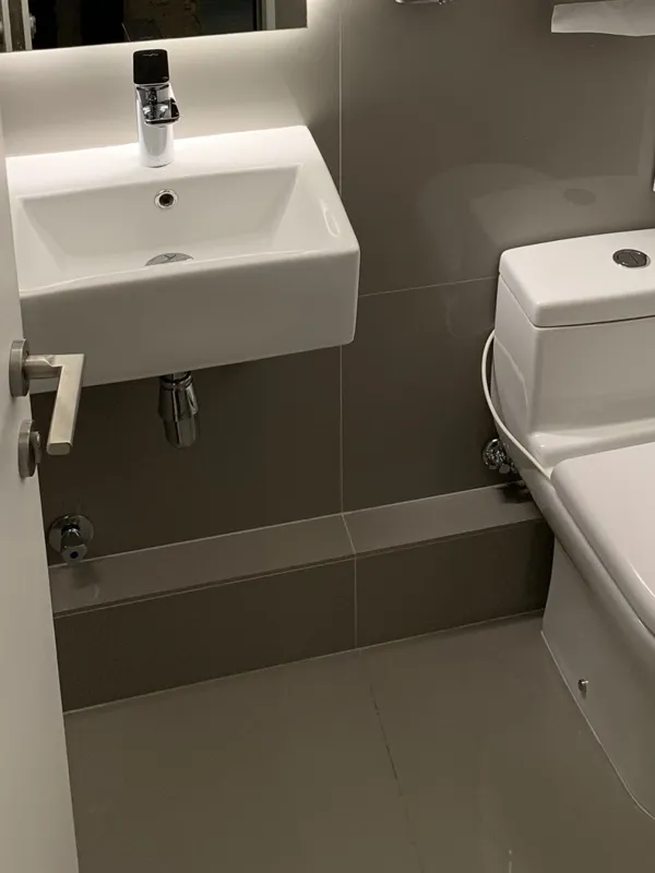 Baño de oficina con lavamanos suspendido y WC