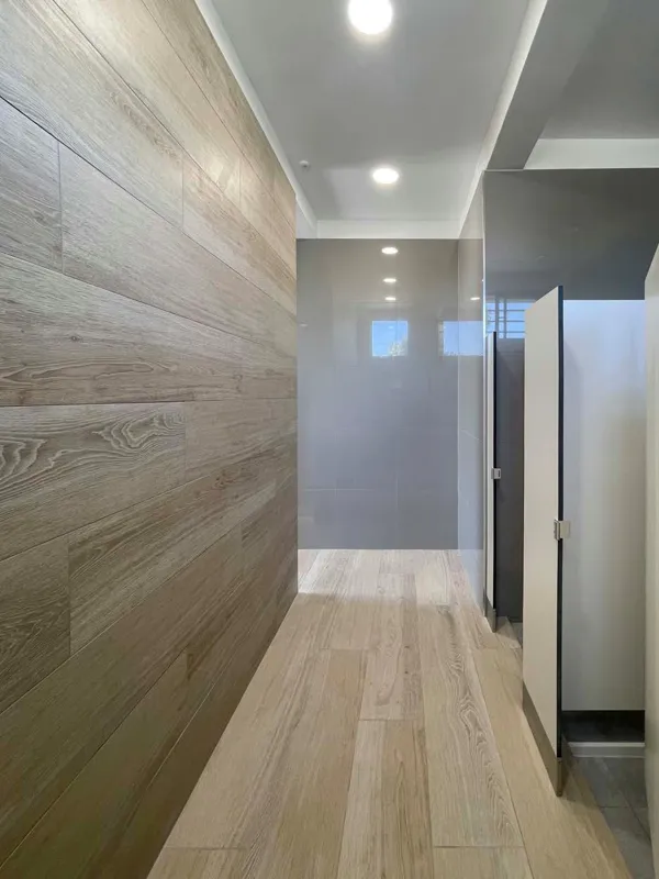 Pasillo de camarines con revestimiento símil madera