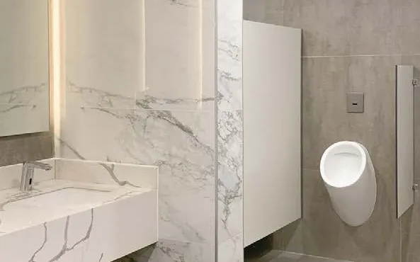 Baño corporativo con revestimiento símil mármol